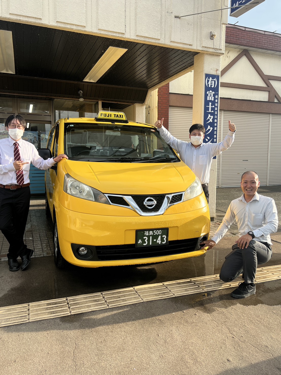 富士タクシー本社前でジャンボタクシーと一緒に写るスタッフ3名